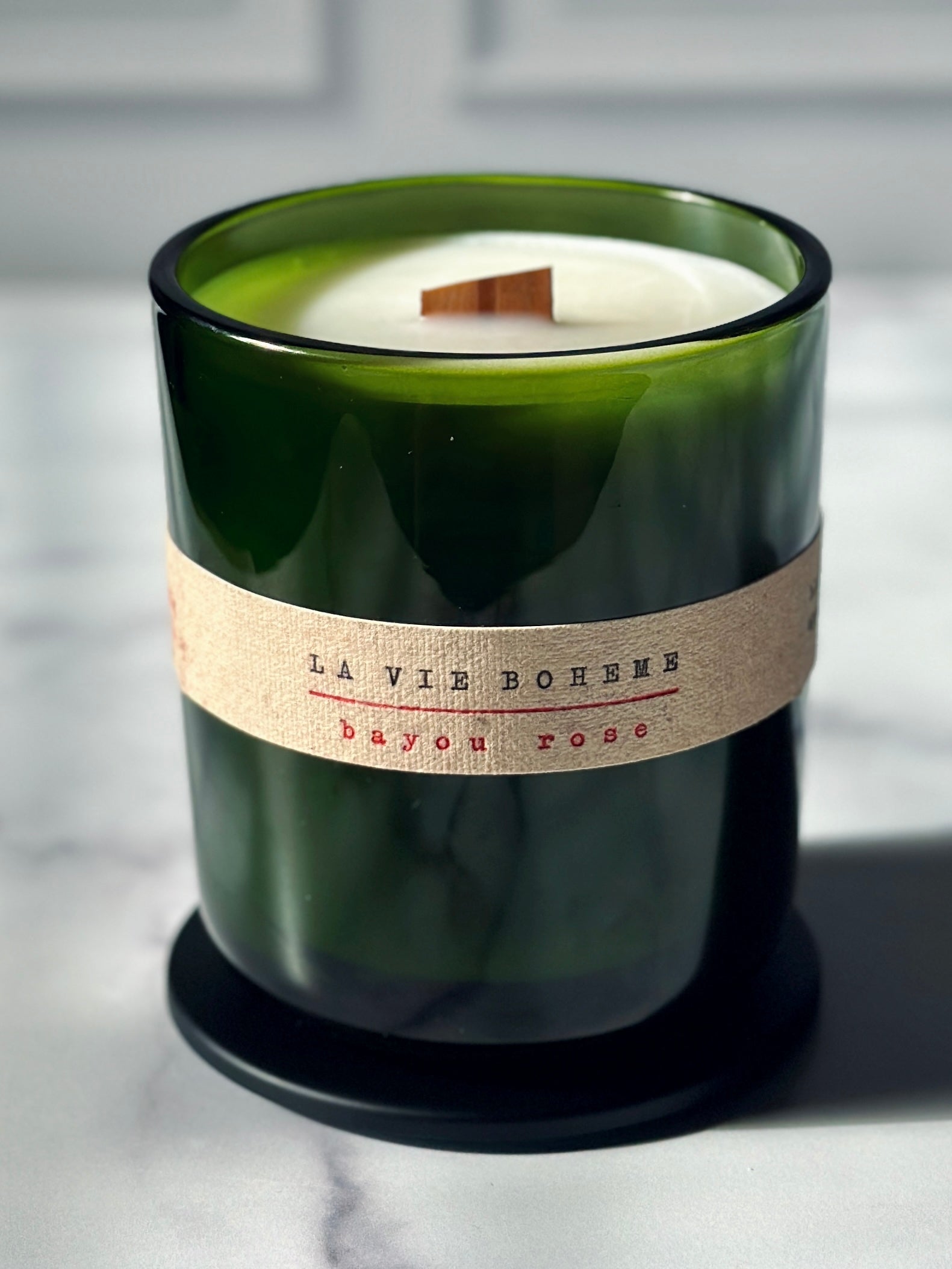 14 oz candle in green glass jar made from coconut olive oil wax blend with typewritten label, and a black lid