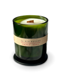 Olive oil coconut apricot wax candle in a green glass jar with a typewriter label on a white background