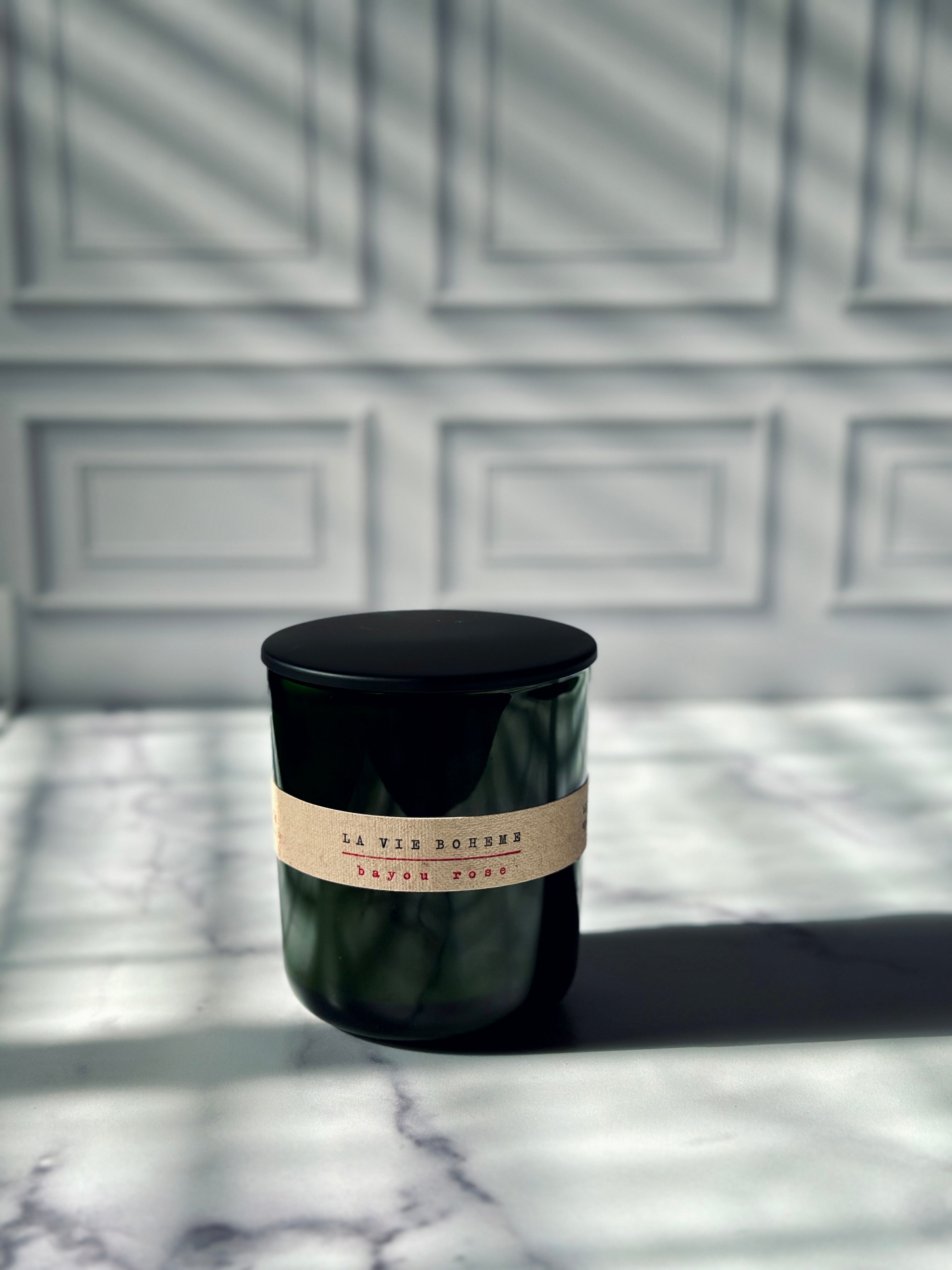 La Vie Boheme candle with black lid on dark green refillable glass jar — luxury bohemian scented candle Bayou Rose Botanicals New Orleans